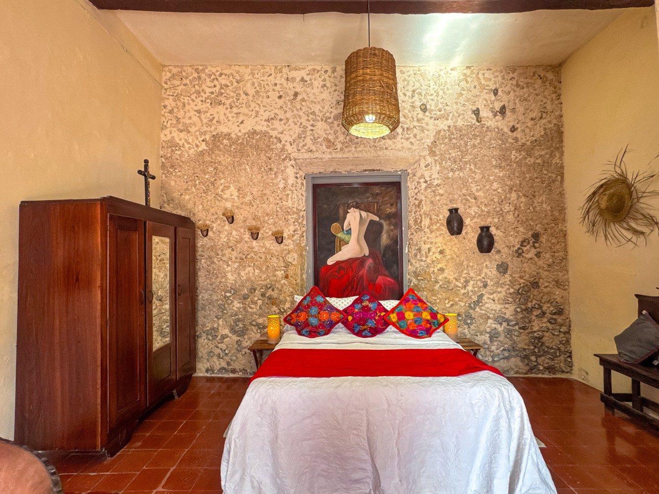 Habitación con muro de piedra y textiles rojos